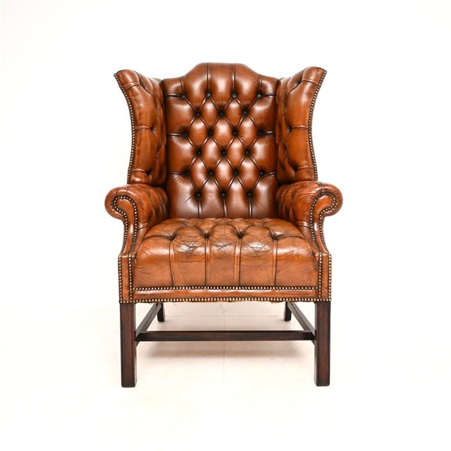 An exceptional antique deep buttoned leather wing back armchair. This was made in England, it dates from around the...