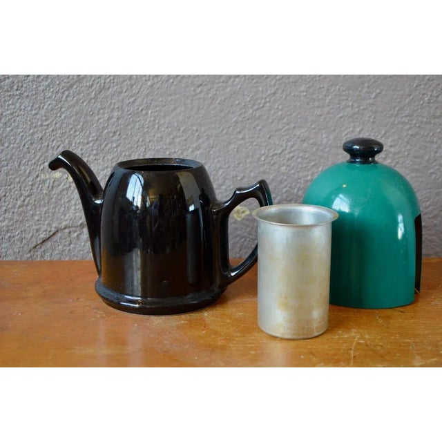 Tea time takes colors with this beautiful teapot 80s in shiny black porcelain, it is topped with a bell cover bright green...