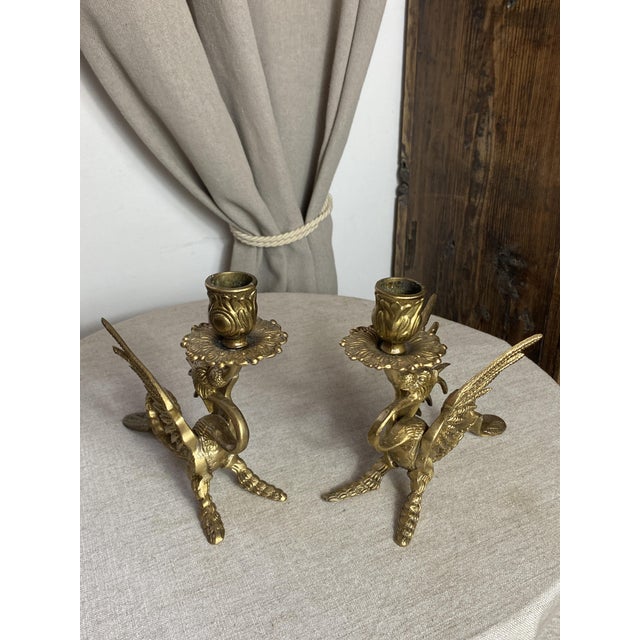 Pair of gilt bronze candlesticks depicting fantastic mythological creatures (such as a dragon, a griffin, a phoenix, or a...
