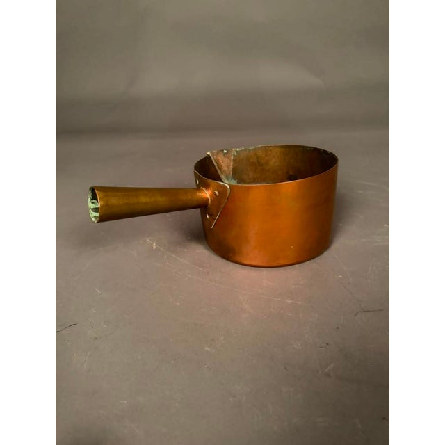 Charming French copper saucepan, handmade circa 1890, featuring a distinctive hollow handle designed to accommodate a...