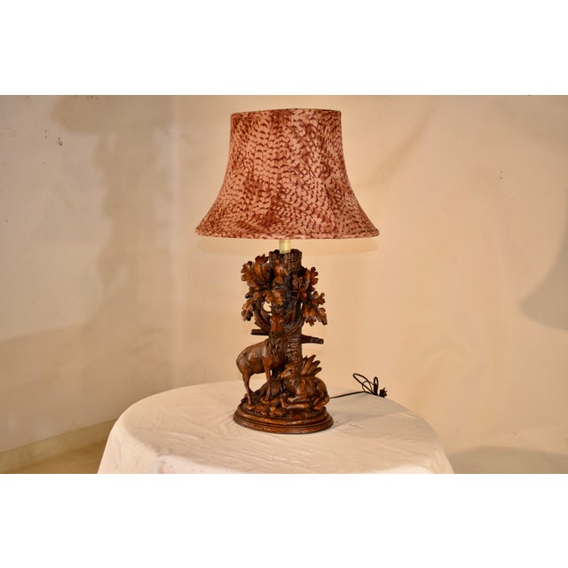 Wonderful cast lamp in the Black Forest style of wood carving. The lamp depicts a tree in the background with a standing...