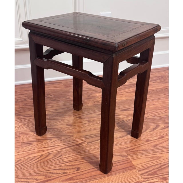 This elegant vintage piece is a traditional Chinese Ming-style side table featuring a clean rectangular top with a...