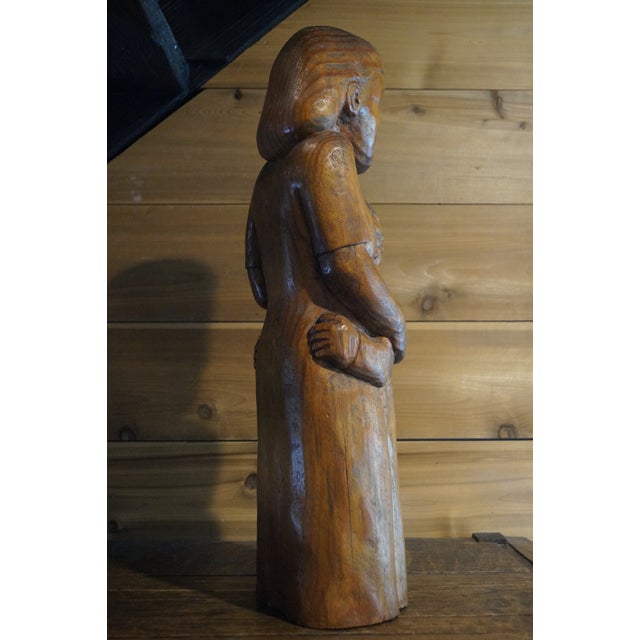 A wonderful one-of-a-kind wood sculpture which is a very stylized mother comforting a child. This piece was most likely...