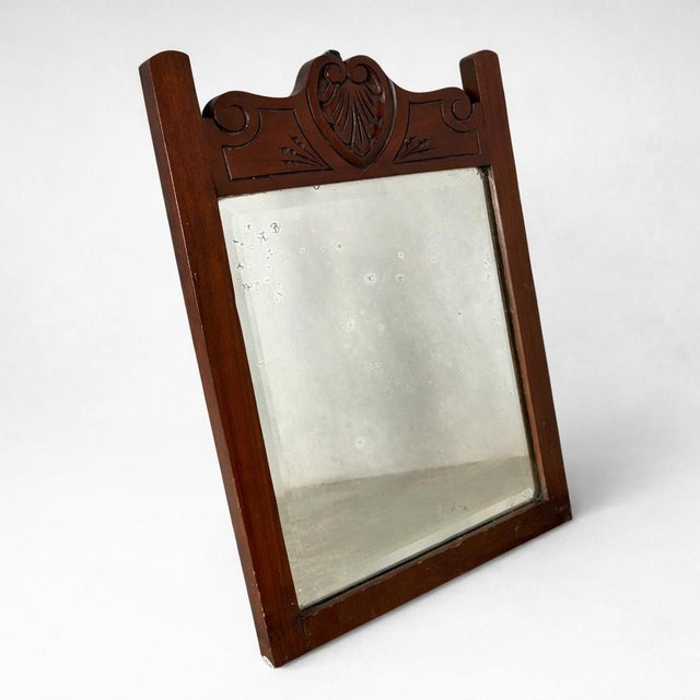 A charming French farmhouse style wall mirror crafted in richly toned mahogany and adorned with decorative carved...