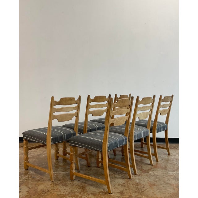 A set of Henning Kjaernulf mid-century high backed 'razorblade' dining chairs with a very handsome seats in a striped gray...