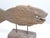 This rustic carved wooden fish is mounted on a block of wood.