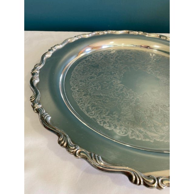 This vintage American silver plate tray by Oneida showcases timeless elegance with its ornate raised scroll border and...