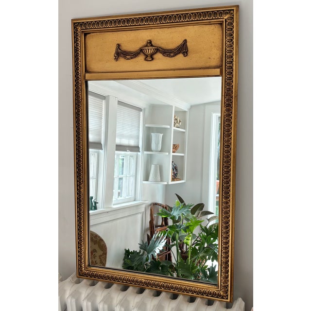 Delightful classic French Trumeau in a rich gold gilt accented with urn and swag motif. Mirror has a lovely warm patina....