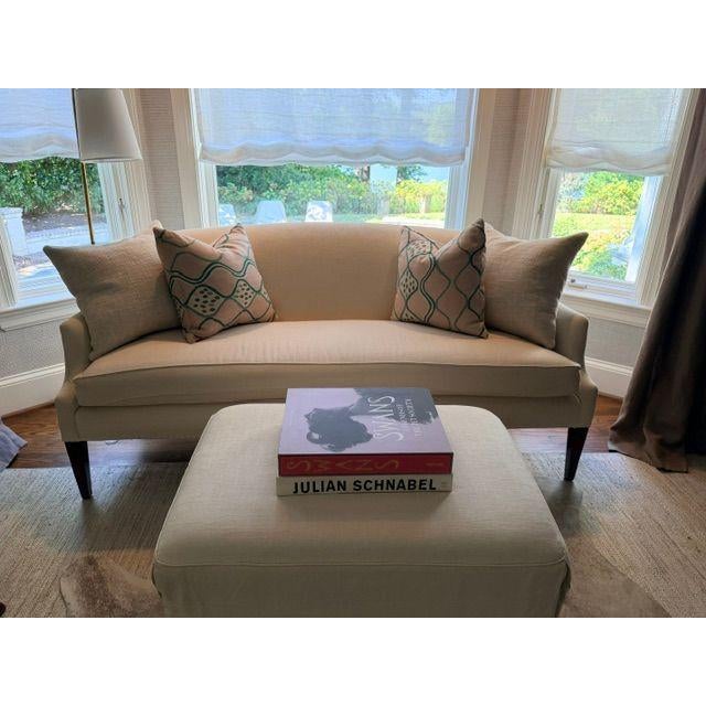 Elegantly upholstered settee featuring a curved back, sloping arms and a generous single bench cushion. Upholstered in a...