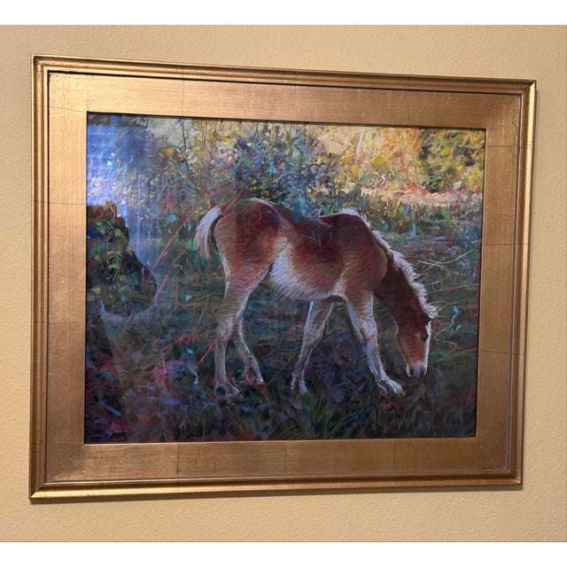 This artwork depicts a young horse, immersed in a lush, vibrant landscape, its soft fur illuminated by dappled sunlight....