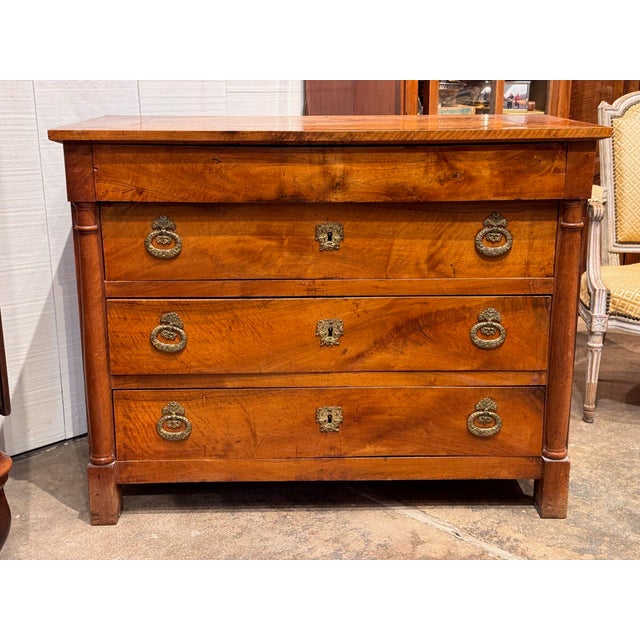 19th century French Empire walnut commode with a frieze drawer over three long dovetailed drawers, flanked by columns and...