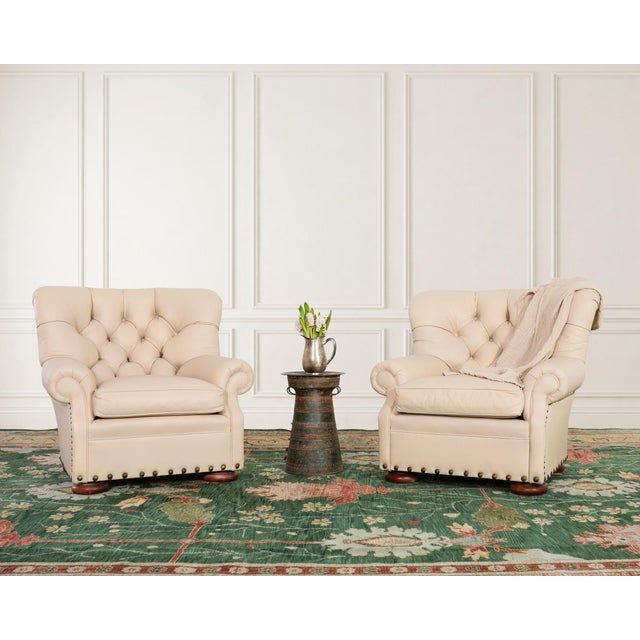 A handsome tailored four-piece seating group consisting of a pair of large tufted leather wingback writer's chairs and a...
