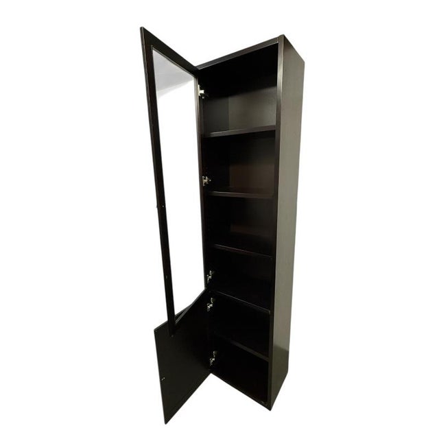 Design Plus Gallery presents a tall, narrow wood display cabinet designed for vertical storage and presentation. This...
