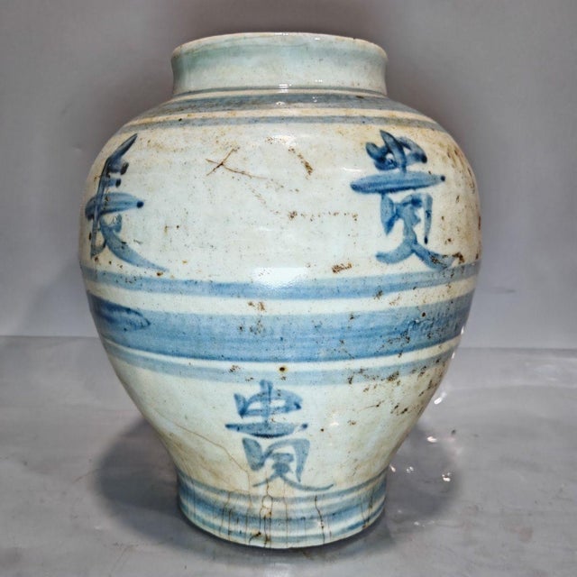 A charming antique Chinese hand-thrown ceramic jar decorated with hand-painted cobalt blue calligraphy characters and...