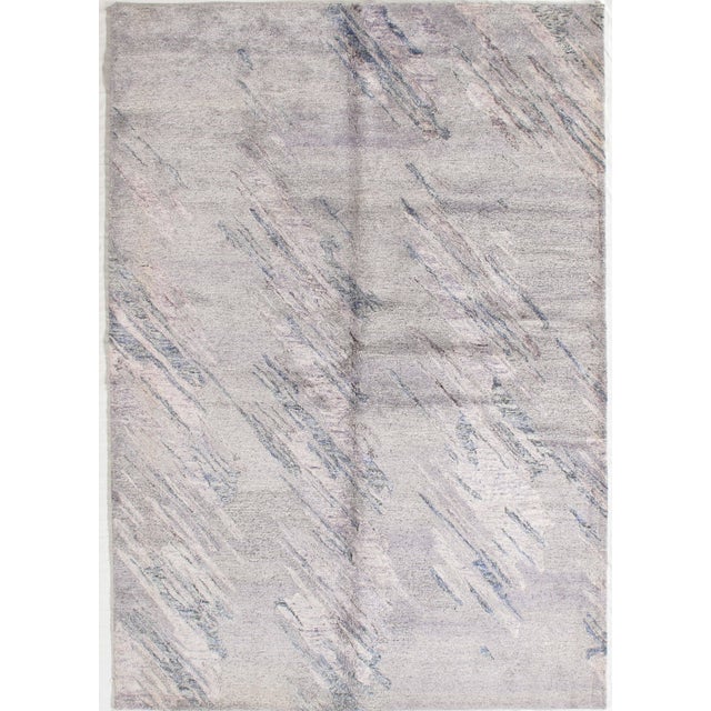 Hand-knotted modern rug featuring a soft abstract composition with diagonal, layered textures across a light neutral...