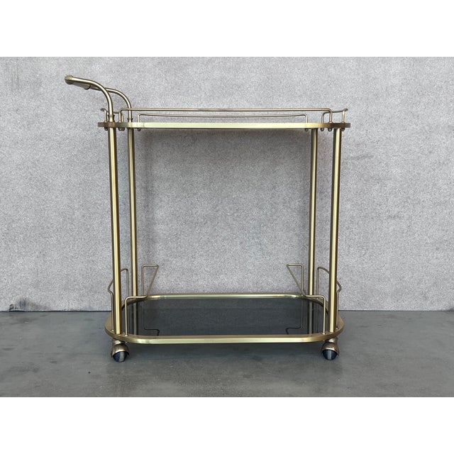 Fabulous brass bar cart with smoked glass Proudly showcase your finest decanters and stemware! Brass handle. This piece is...