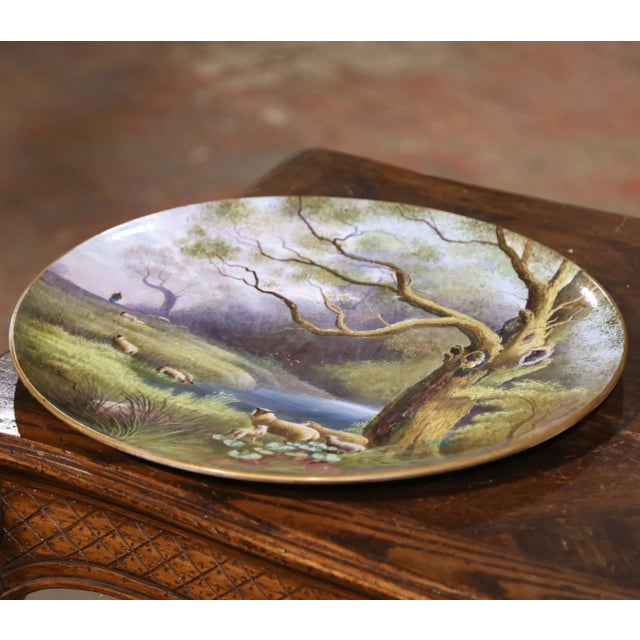 Charming in both scale and subject, this antique porcelain charger captures the pastoral beauty of the French countryside....