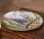 Charming in both scale and subject, this antique porcelain charger captures the pastoral beauty of the French countryside....