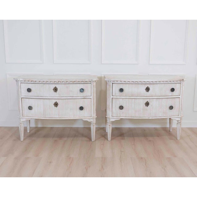 A beautifully balanced pair of 20th century Italian neoclassical commodes, distinguished by their softly bowed fronts,...