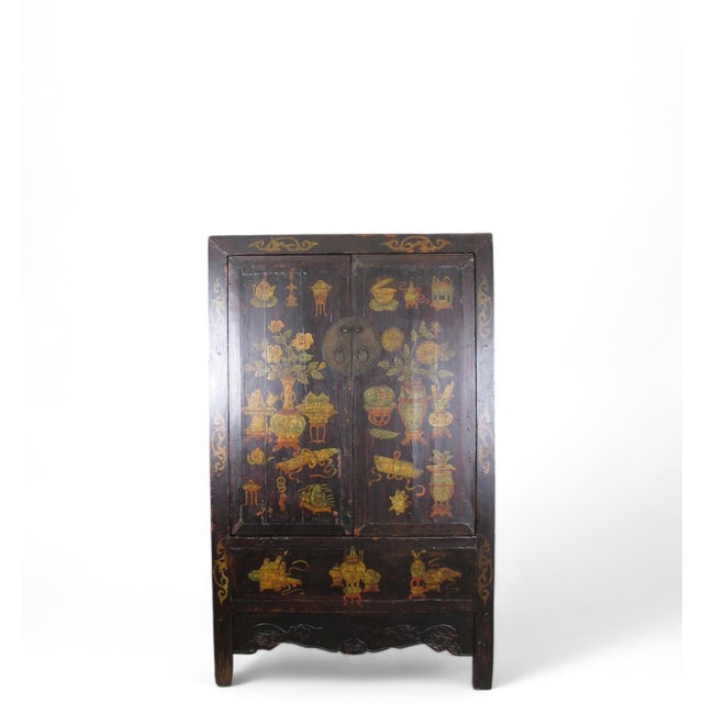 The two panel doors of this antique black cabinet are adorned with the hand-painted image of lively flowers and auspicious...