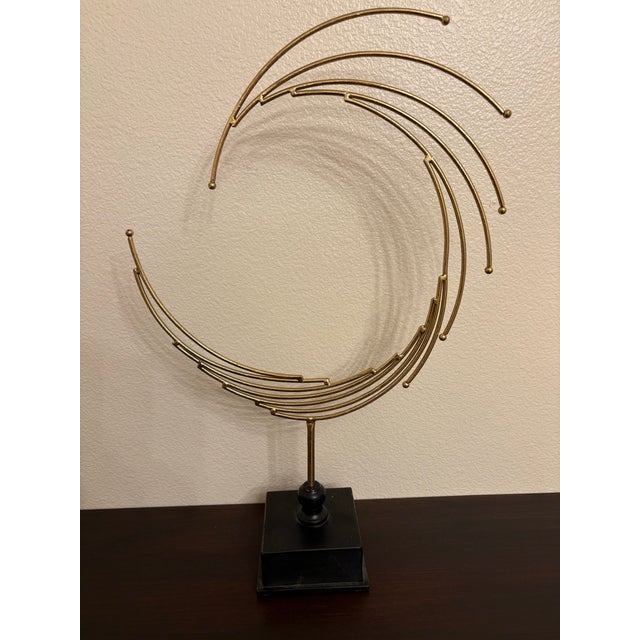 This golden brass style sculpture represents a opening portal in space. It is a be3lief that there are portals that can...