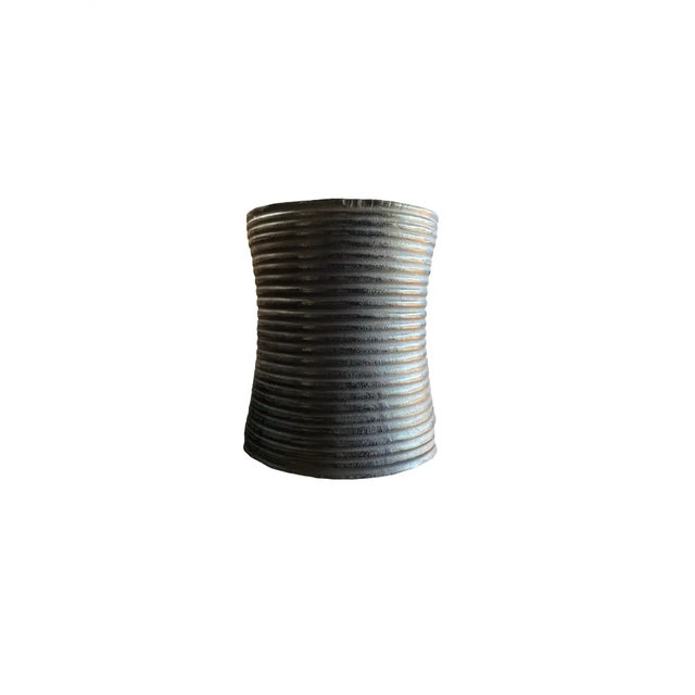 A wonderfully sculptural round side table with a hand-carved, ribbed design. Its rich black pigment was achieved through...