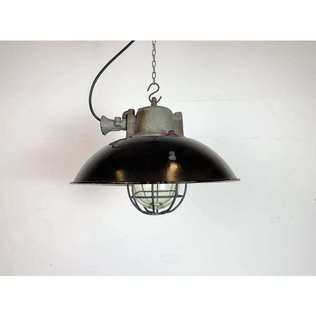Industrial hanging lamp manufactured by Elektrosvit in former Czechoslovakia during the 1960s. It features a black enamel...