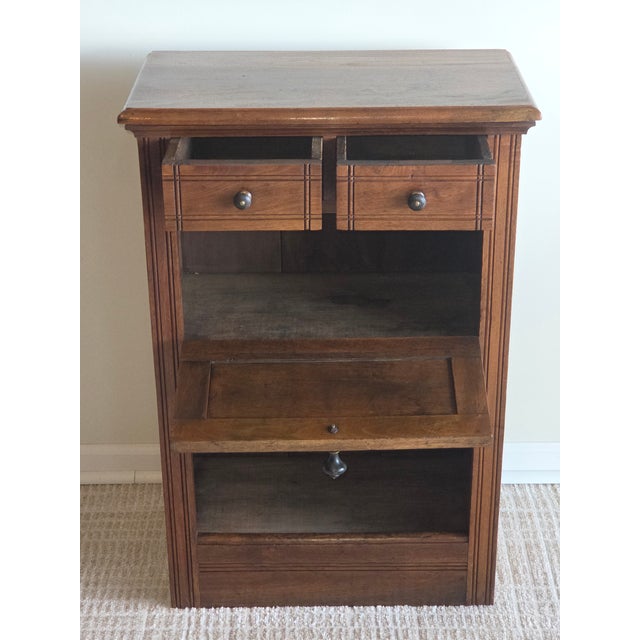 This antique cabinet, crafted from solid walnut, showcases the distinct design characteristics of the late 19th-century...