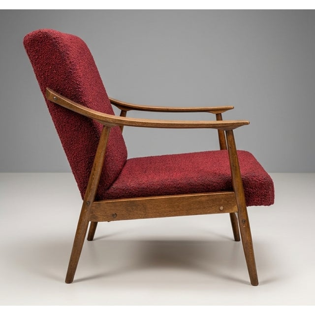 A pair of sculptural mid century armchairs produced by TON in former Czechoslovakia during the 1960s. The chairs feature...