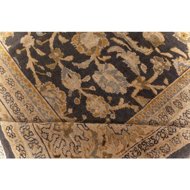 This circa-1920 antique Persian rug features an intricate all-over design of stylized floral motifs, arabesques and vinery...