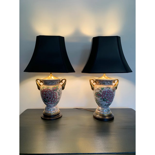 These double handled gilded vase lamps have an exquisite floral design of chrysanthemums in pinks and greens outlined in...