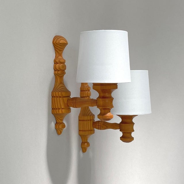 Swedish Mid-Century Design Wall Lights, 1960s to 1970s The sconces feature intricately turned Swedish pine wood backplates...