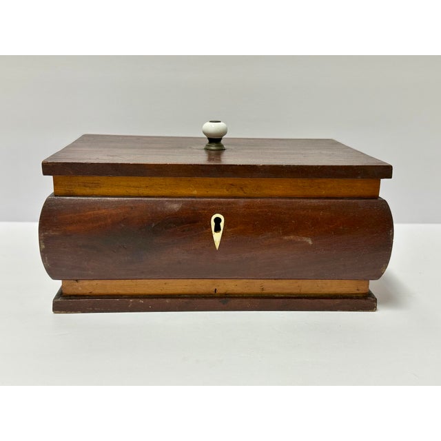 Solid wood Victorian tea caddy from the 1800s. It is bombe shaped with contrasting lighter wood banding and a small...