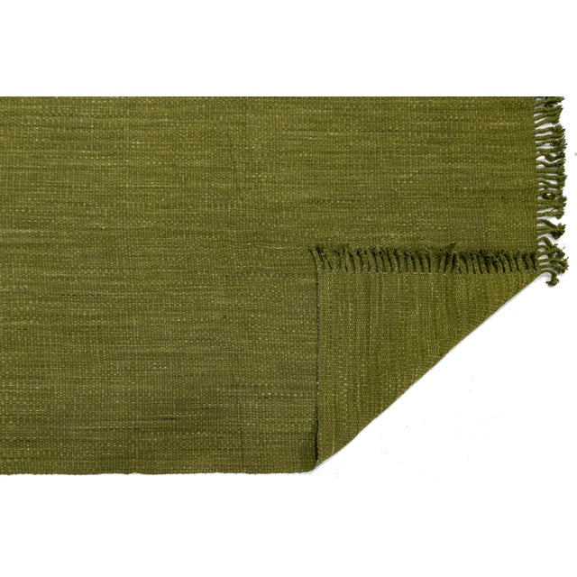 Elevate your space with this Modern Kilim-style wool rug, featuring a rich, earthy olive green palette. This hand-woven...