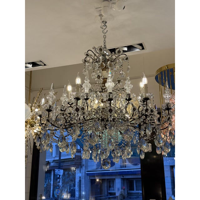 A most charming italian 19th century pressed patinated metal, giltwood and crystal twelve lights genovese chandelier. This...