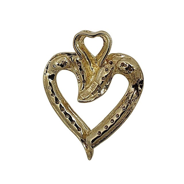 Estate .33 CTW diamond heart pendant. This estate heart pendant is crafted in 10 karat yellow gold featuring .33 carat...