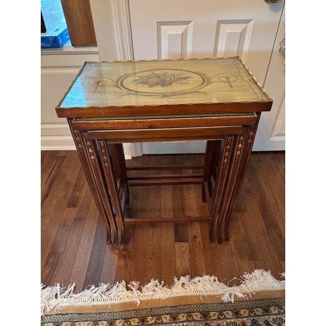 Three hand painted tables with lovely floral motifs in each top with a glass covering. Also painting in the legs. The top...