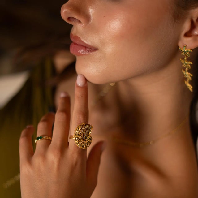 Bring a touch of ocean magic to your style with the Mystic Shell Gold Adjustable Chunky Ring. This unique design features...