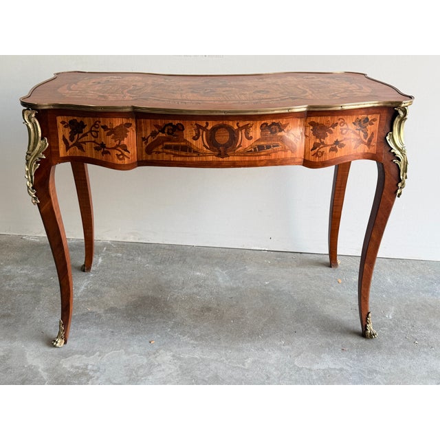 Rococo-style marquetry inlaid desk with floral motifs and featuring rich marquetry inlay and ornate gilt bronze (ormolu)...