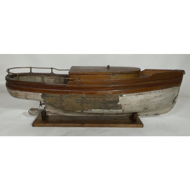 Nice old antique launch model with planked hull and deck. The hull has a propellor. The heavy brass railing surrounds the...