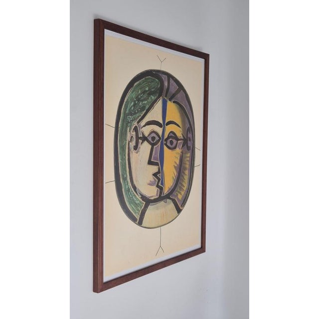 An exquisite framed shiny polychrome print of Picasso Vallauris ceramic plates depicting a colorful face. The color print...