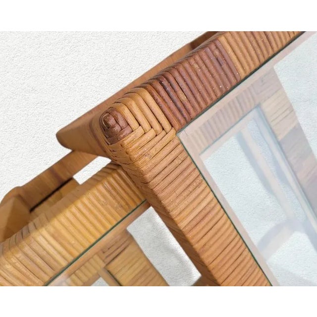 A beautiful vintage set of 3 glass top rattan wrapped nesting tables. The tables have a nice light variegated color in a...