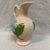 Made by Hull pottery art, it features a glossy pink background with a hand-painted blue magnolia flower and green leaves.