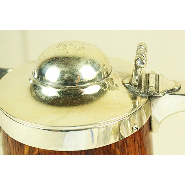 An English oak and silver lidded ale tankard dating from the end of the 19th century. The silver is Sheffield silver...