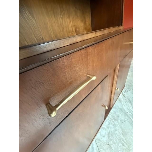 A beautifully restored Mid Century Modern china cabinet by Craddock Furniture Company, featuring warm walnut tones and the...