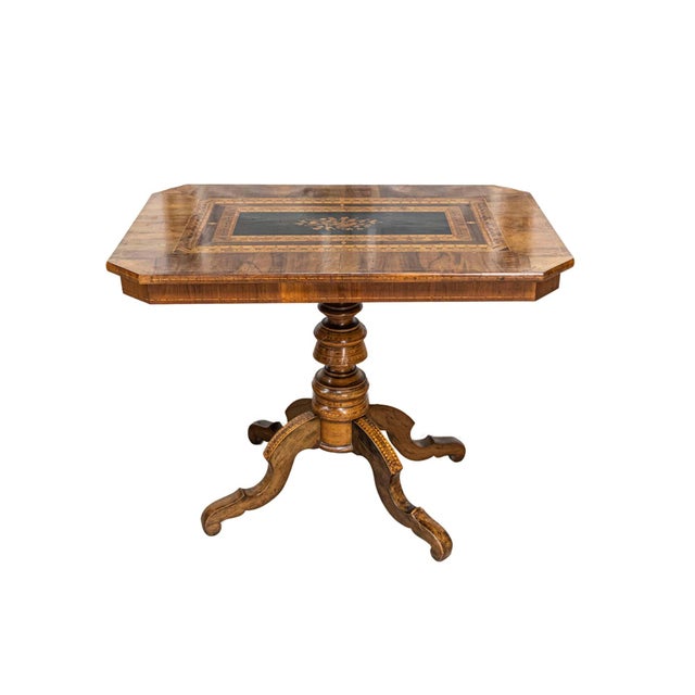 An Italian walnut and mahogany center table from the 19th century with floral marquetry and quadripod base. This exquisite...
