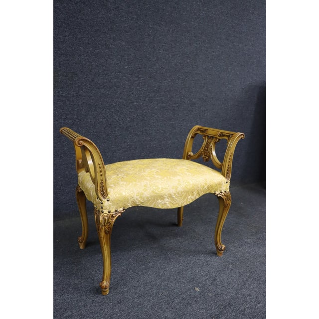 Italian-style vanity bench featuring a carved giltwood frame with graceful curved legs and decorative scrollwork. The seat...
