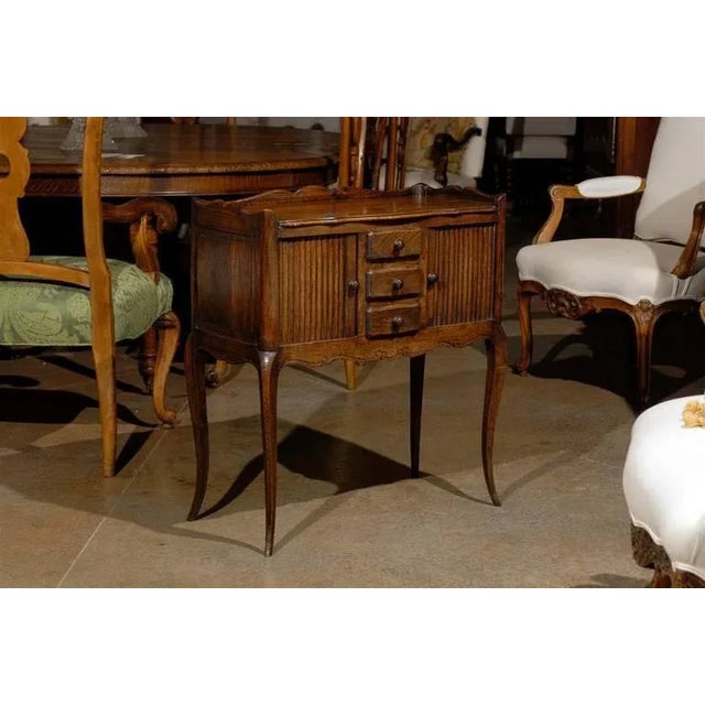 A French oak bedside table with two reeded sliding-door cabinets and three drawers from the late 19th century. This French...