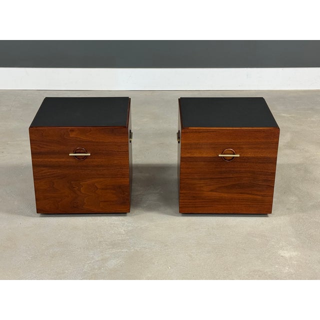A pair of mid century modern walnut end tables with black scratch resistant formica tops and brass accents finished on all...