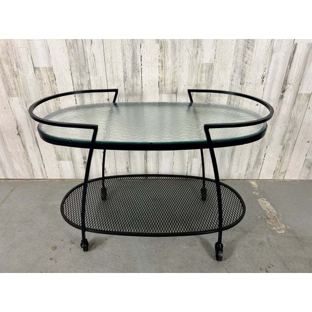 Modernist iron bar cart made by Woodard patio furniture company. Maintains it's original pebble glass with new powder coat...